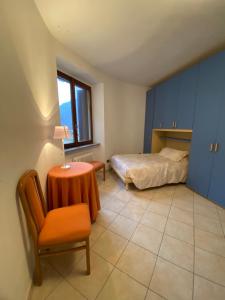 een slaapkamer met een bed, een tafel en een stoel bij Casa di borgo vista lago in Valsolda