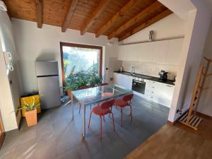 cocina con mesa de cristal y sillas rojas en Kikka's gem - Spacious Apartment 20km from Milan, en Seregno