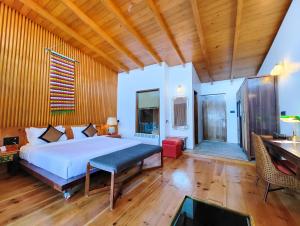 a bedroom with a large bed and a wooden ceiling at Timilo Boutique in Tawang