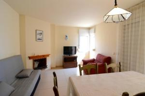 a living room with a couch a table and a television at Terrassa del Mar 6-1-B in L'Escala