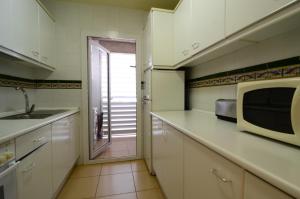 a kitchen with a sink and a microwave at Terrassa del Mar 6-1-B in L'Escala