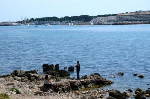 a man standing on some rocks near the water at Terrassa del Mar 6-1-B in L'Escala