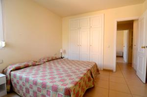 a bedroom with a bed with a checkered blanket at Terrassa del Mar 6-1-B in L'Escala +9 photos