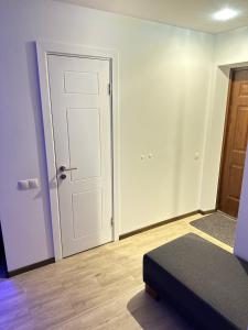 een lege kamer met een deur en een bed bij Studio apartment in Valmiera