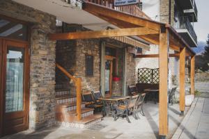 un patio con mesa y sillas y un edificio en Casa Samarra, en Vall de Cardós