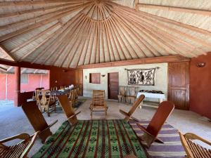 ein Wohnzimmer mit einem Tisch, Stühlen und einer Decke in der Unterkunft Bégué Lodge in Dinouar