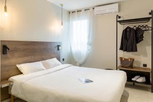 加龍河畔波泰的住宿－三葉草酒店，卧室设有一张白色大床和一扇窗户。