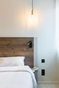 een slaapkamer met een wit bed en een houten hoofdeinde bij Le Trèfle in Portet-sur-Garonne