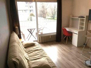 - un salon avec un canapé, un bureau et une fenêtre dans l'établissement Studio LEON, à Chambéry