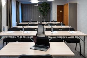 a classroom with tables and a laptop on top of it at Hotel Villa Wesset in Pärnu