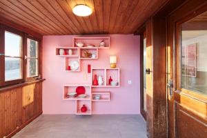 un pasillo con una pared rosa con estanterías en pop-up stuub feldberg, en Feldberg