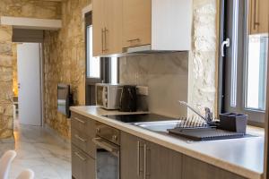 a kitchen with a sink and a microwave at Phaedrus Living: Luxury Stone House Armou in Paphos