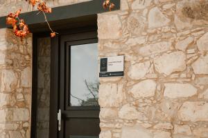 una porta di un edificio in pietra con un cartello sopra di Phaedrus Living: Luxury Stone House Armou a Paphos