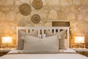 a bedroom with a white bed with two lamps at Phaedrus Living: Luxury Stone House Armou in Paphos