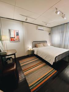 a bedroom with a bed and a table and a rug at Ceraclay Home in Nan