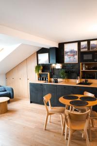 een keuken en een woonkamer met een tafel en stoelen bij Apartament nad Czarnym Potokiem in Krynica Zdrój