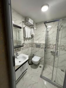 a bathroom with a shower and a toilet and a sink at Efe Apart Hotel in Istanbul