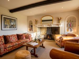 a living room with a couch and a fireplace at Green Farm House in Cirencester