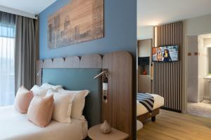 a bedroom with a large bed with pillows at Citadines La Défense Paris in Courbevoie
