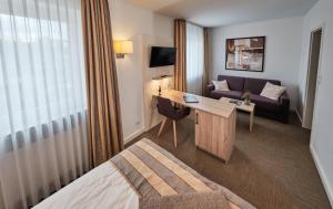 a hotel room with a bed and a desk and a couch at Hotel zum Adler - Superior in Bonn