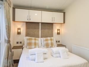 um quarto com uma cama com lençóis brancos e almofadas em Draco em Morpeth