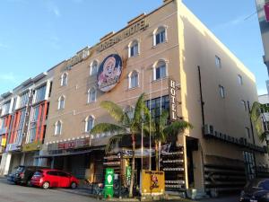 a building on a street with cars parked in front of it at Aladdin Dream Hotel in Johor Bahru