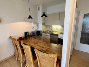 a kitchen with a wooden table and chairs at Haus am Deich Wohnung 10 in Dahme