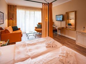 ノルドドルフにあるSonnenresort Hüttmannのベッドとリビングルームが備わるホテルルームです。