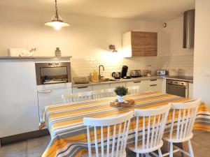 a kitchen with a table and chairs in a room at Un Nid dans la Pinède in Lacanau