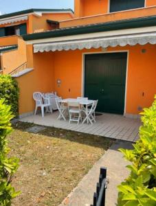 カオルレにあるIRIS 20 In posizione strategica, indipendente, all'interno del Villaggio dei Fioriの建物の前にパティオ(テーブル、椅子付)