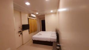 Postel nebo postele na pokoji v ubytování HOTEL RIGGA INN KOKILABEN DHIRUBHAI AMBANI Hospital