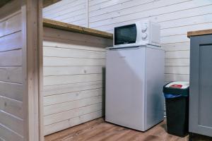 um micro-ondas em cima de um frigorífico numa garagem em Gombaszög 
