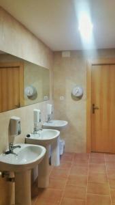 a bathroom with two sinks and a mirror and a toilet at El Camino de las Estrellas in Navarrete