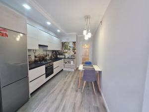 a kitchen with white cabinets and a table and chairs at Apartament, sectorul Buiucani in Chişinău