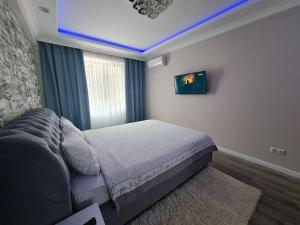ein Schlafzimmer mit einem Bett und einem blauen Licht in der Unterkunft Apartament, sectorul Buiucani in Chişinău