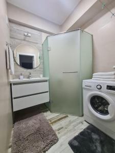 a bathroom with a washing machine and a mirror at Apartament, sectorul Buiucani in Chişinău