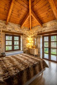 a bedroom with a large bed in a stone wall at Villa MYLOS Kalavrita in Kalavrita