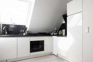 une cuisine blanche avec un évier et une fenêtre dans l'établissement THE Penthouse at Eco Smart Apartments, à Nuremberg