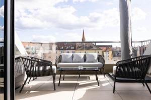 a balcony with a couch and chairs and a view at THE Penthouse at Eco Smart Apartments in Nürnberg