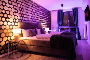 - une chambre dotée d'un lit avec des lumières violettes sur le mur dans l'établissement THE Penthouse at Eco Smart Apartments, à Nuremberg