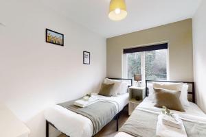 2 camas en una habitación con ventana en Oakwell View - Modern 3 Bed Home en Barnsley