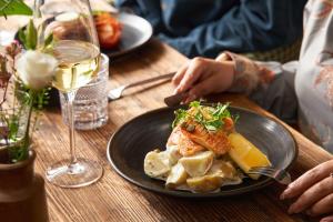 a table with a plate of food and a glass of wine at Hope & Anchor in Hope Cove