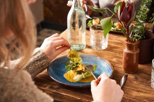 a woman sitting at a table eating a plate of food at Hope & Anchor in Hope Cove