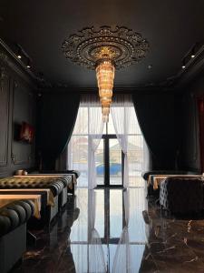 um quarto com um lustre e uma grande janela em WIND HOTEL em Shymkent