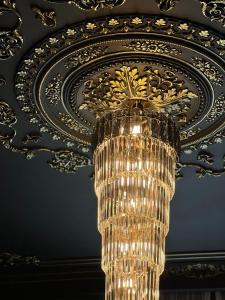 a chandelier hanging from a ceiling in a room at WIND HOTEL in Shymkent