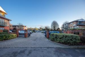 a brick driveway with a gate in a residential neighborhood at Dragonfly House in Maidenhead