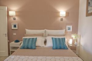 a bedroom with a large bed with blue and white pillows at Tenuta Cesarina in Alessano
