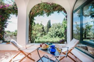 a dining room with a table and chairs and a large window at Villa Tragara by Elite Villas in Capri