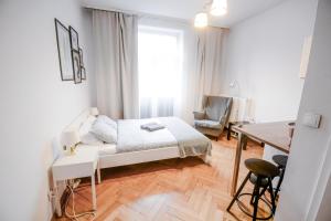 a bedroom with a bed and a desk and a table at SL apartments in Kraków