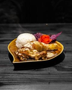 une assiette de nourriture avec du poulet et du riz sur une table dans l'établissement Sapa Farmstay, à Sa Pa